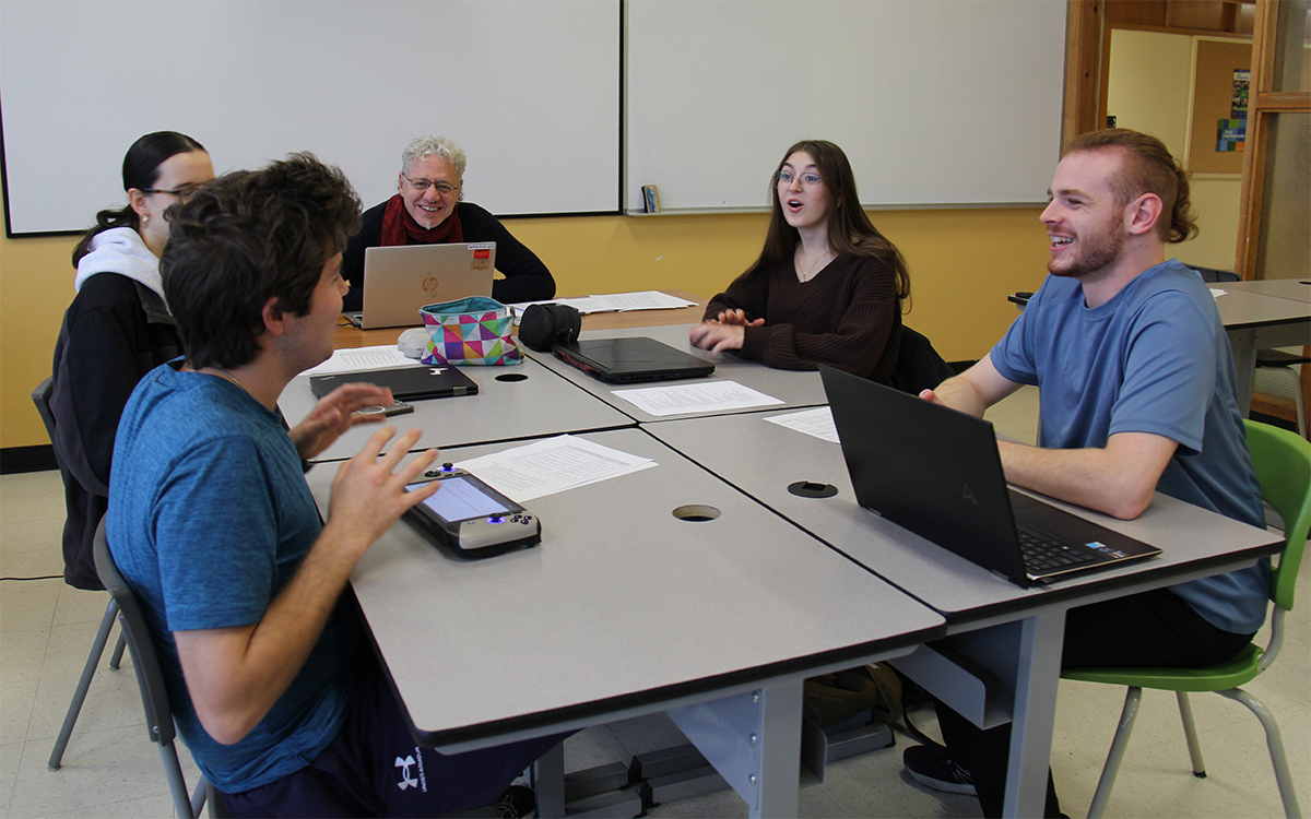 Quatre étudiants et un enseignant dans un groupe de travail en classe