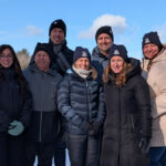 Sept personnes en manteaux d'hiver dans un paysage hivernal