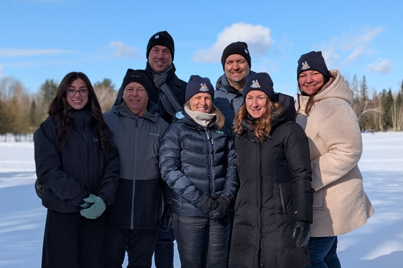 Sept personnes en manteaux d'hiver dans un paysage hivernal