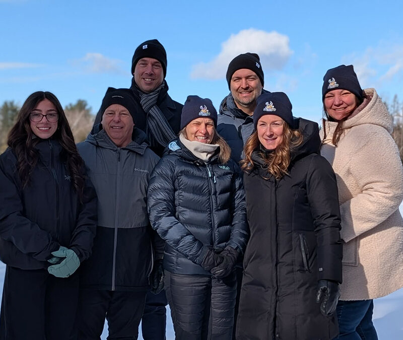Sept personnes en manteaux d'hiver dans un paysage hivernal