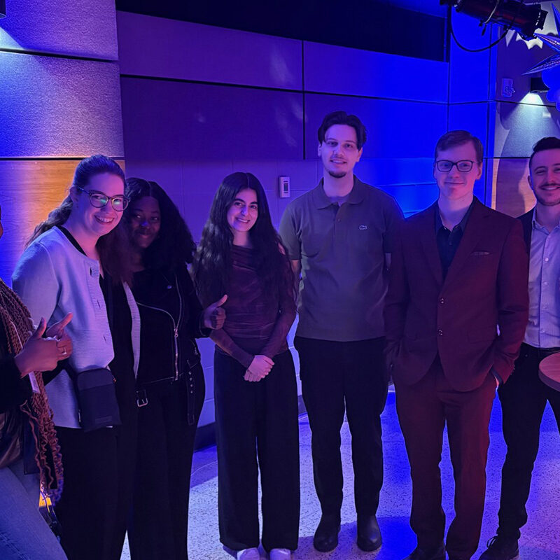 Sept étudiants debout dans une salle de banquet