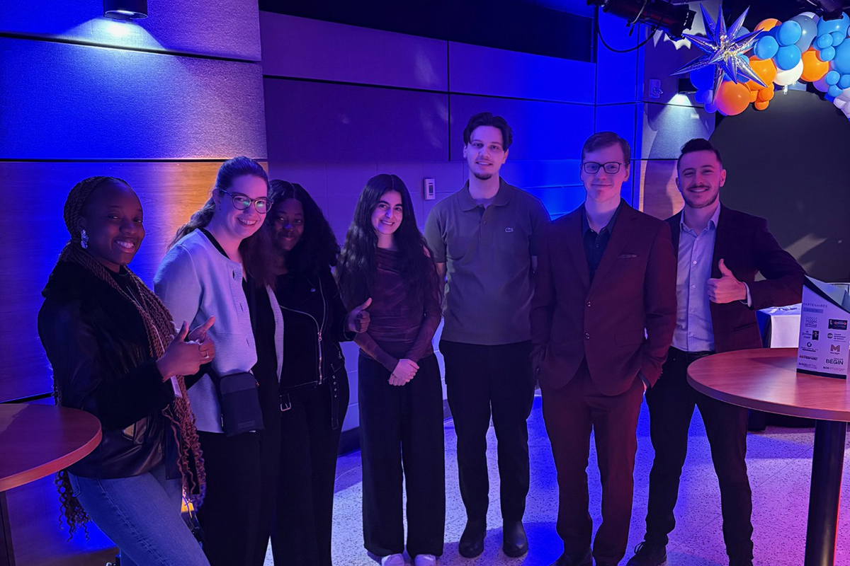 Sept étudiants debout dans une salle de banquet