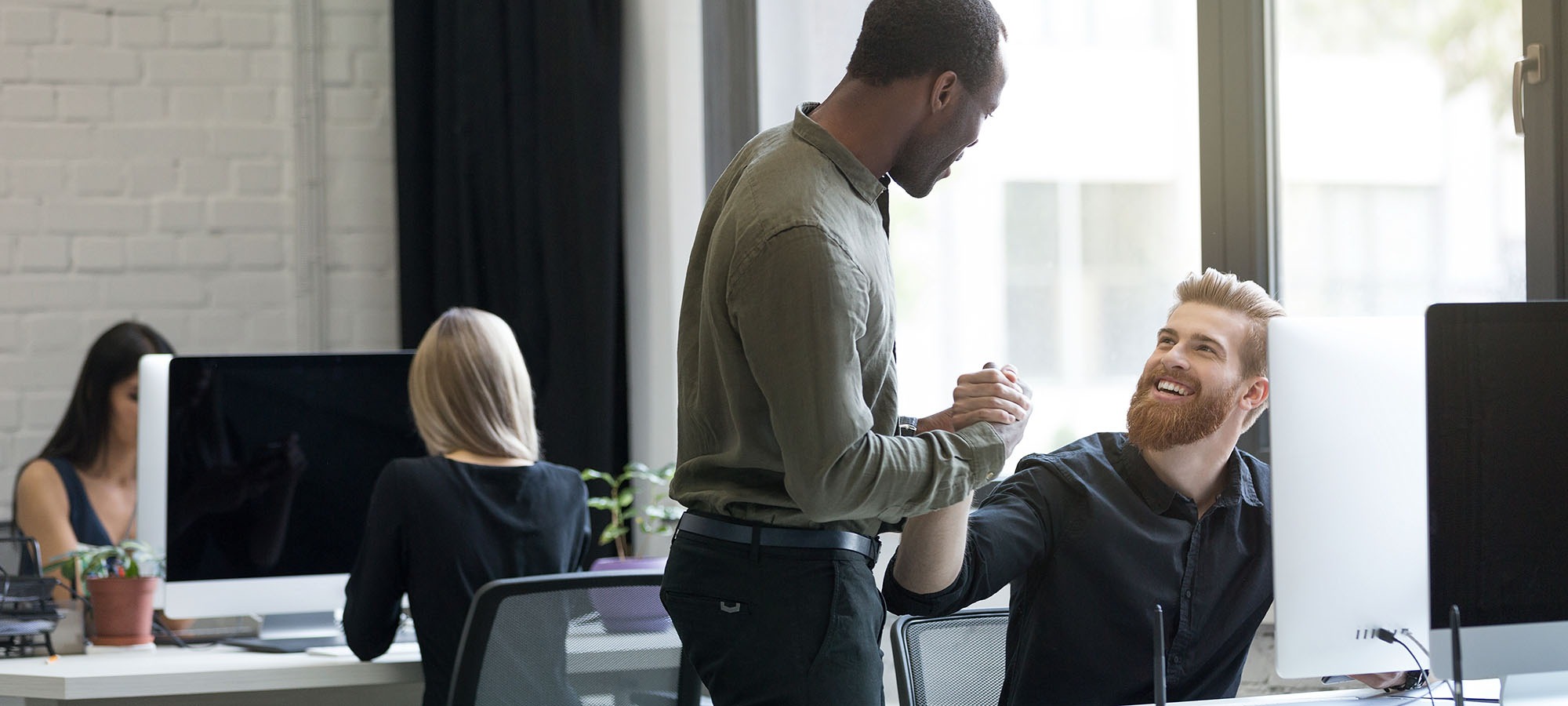 Deux hommes se serrent la main dans un bureau