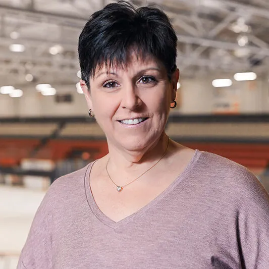 Une femme souriante dans un aréna