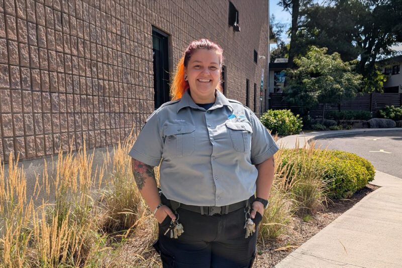 Une agente de sécurité souriante à l'extérieur d'un bâtiment