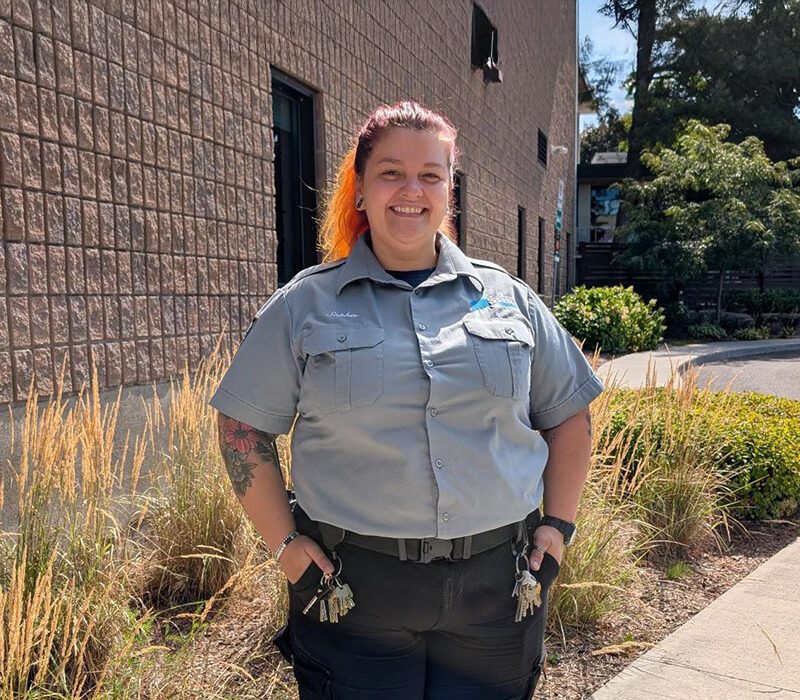 Une agente de sécurité souriante à l'extérieur d'un bâtiment