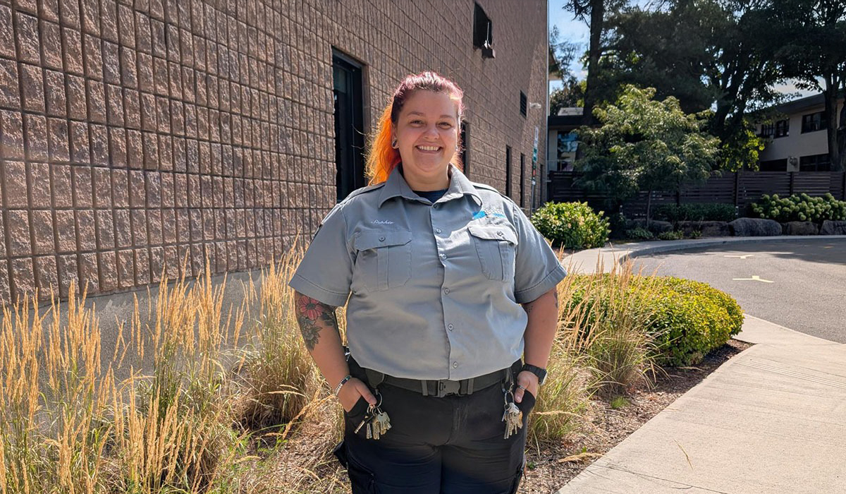 Une agente de sécurité souriante à l'extérieur d'un bâtiment
