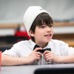 Un petit garçon portant une tuque et un noeud papillon.