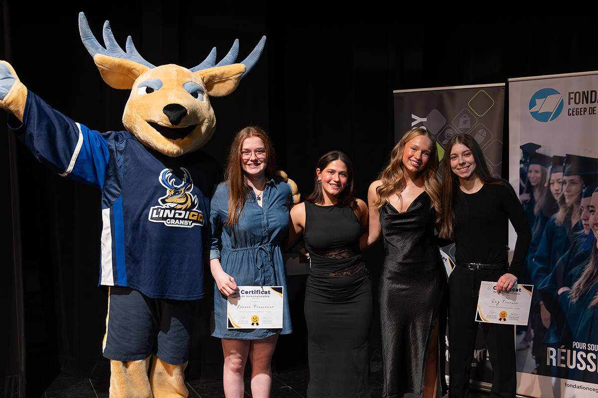 Remise de prix avec une mascotte de cerf et 4 jeunes femmes sur la scène