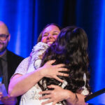 Lors de la remise d'un prix, deux femmes font une accolade