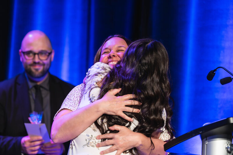 Lors de la remise d'un prix, deux femmes font une accolade