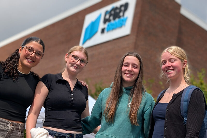 Quatre jeunes femmes à l'extérieur devant l'entrée du Cégep de Granby
