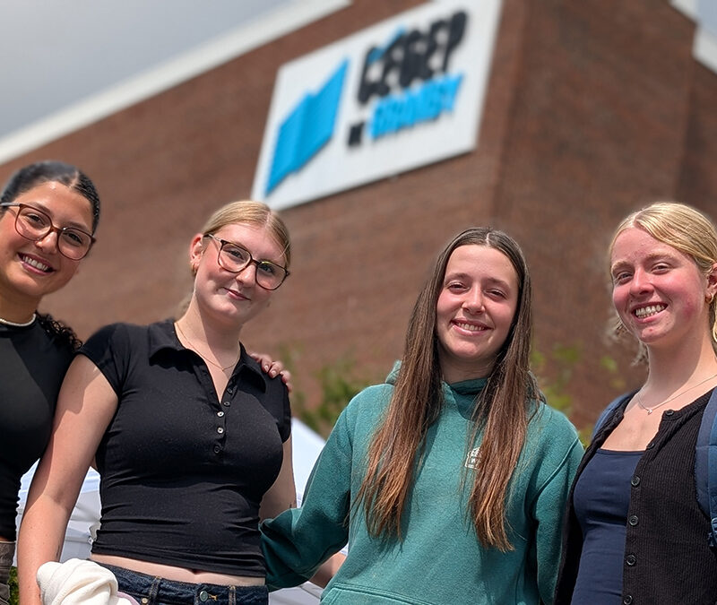 Quatre jeunes femmes à l'extérieur devant l'entrée du Cégep de Granby