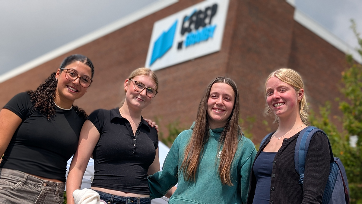 Quatre jeunes femmes à l'extérieur devant l'entrée du Cégep de Granby
